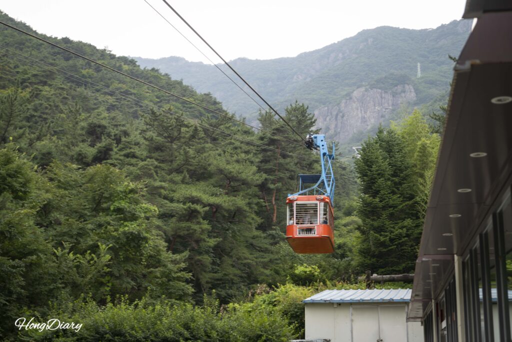 El teleférico del Geumosan descendiendo la montaña con vista panorámica de Gumi y el valle