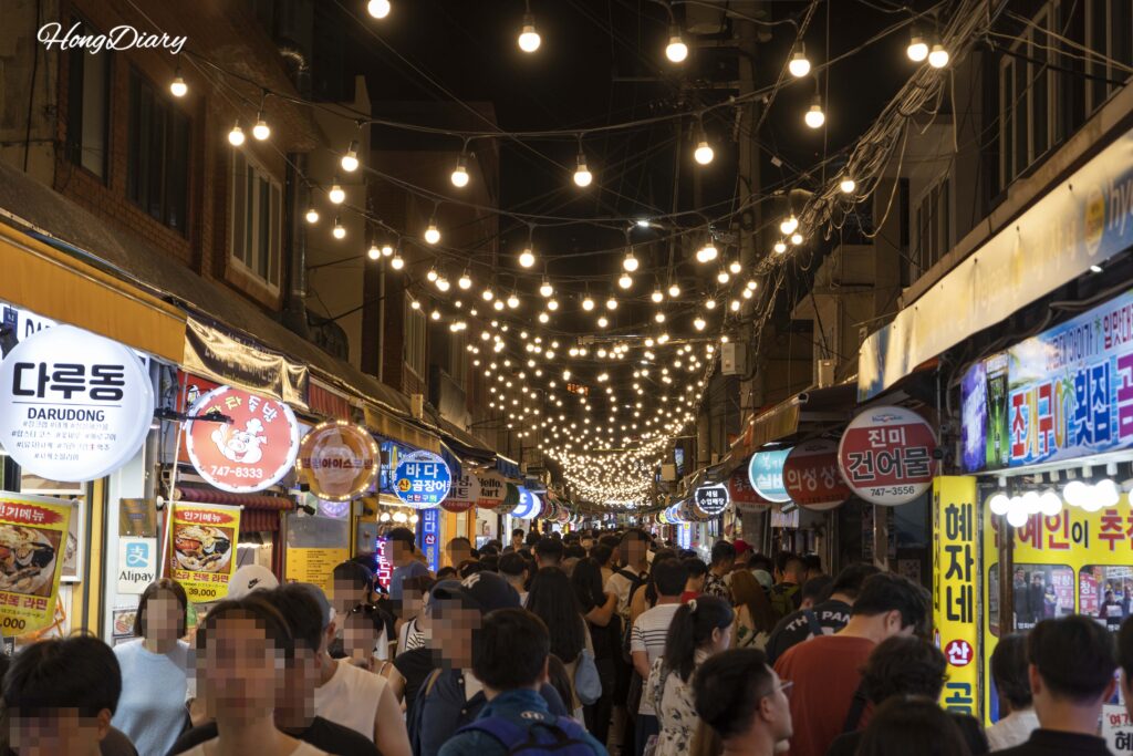 夜の海雲台伝統市場の入口、大勢の人で賑わう様子