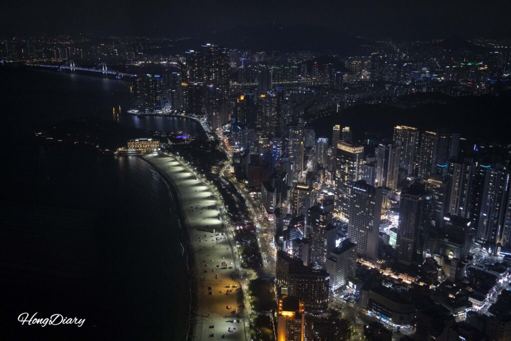 Vista nocturna de la playa de Haeundae y el puente Gwangan desde el piso 98 de Busan X the Sky