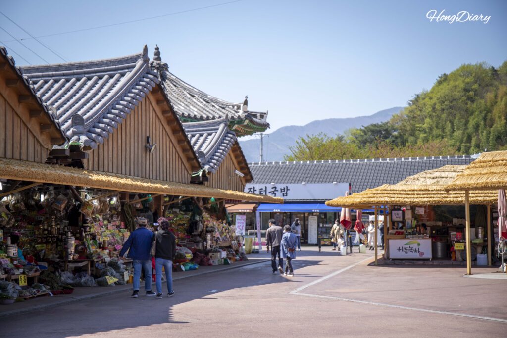 Overview of Hwagae Market with thatched roof buildings along the main lane