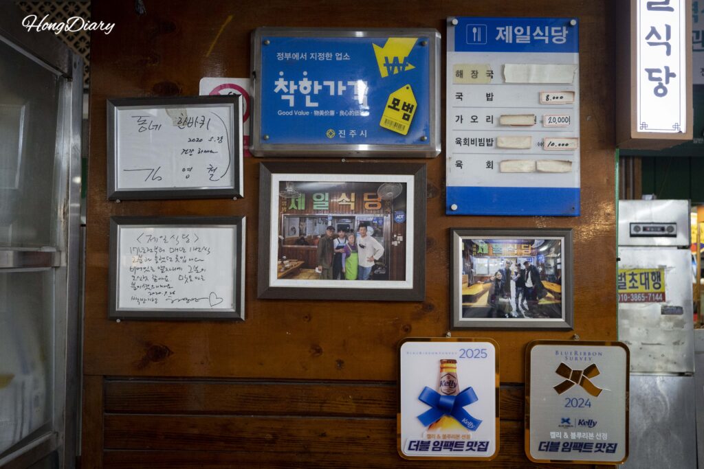 Wall inside Jeil Restaurant showing framed photos from Korean TV broadcasts and years of history