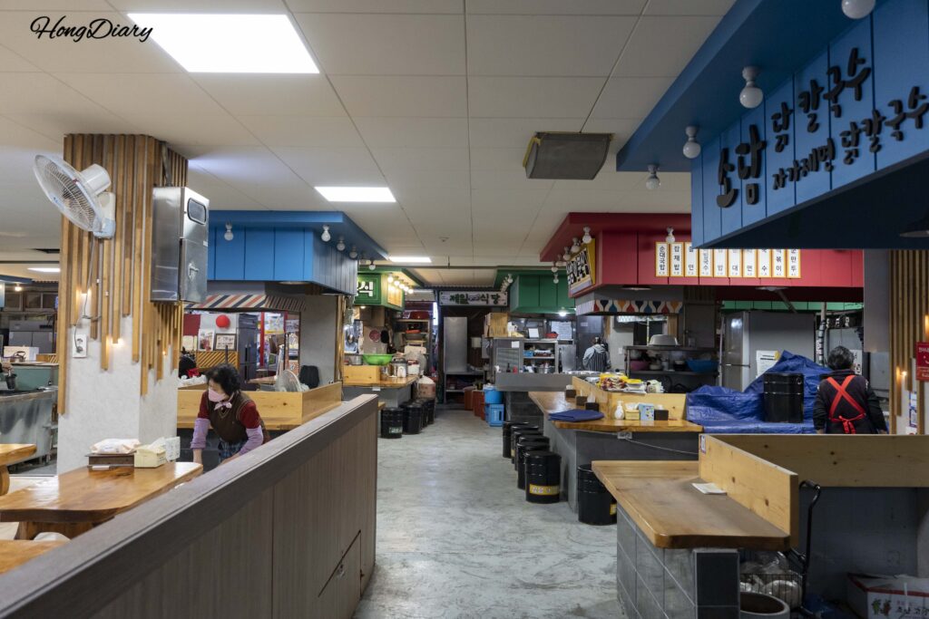 晋州中央市場の食べ歩き横丁内部の細い通路と飲食店の看板