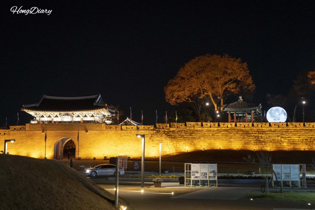 Jinjuseong Fortress walls illuminated at night in Jinju, reflecting light onto Namgang River