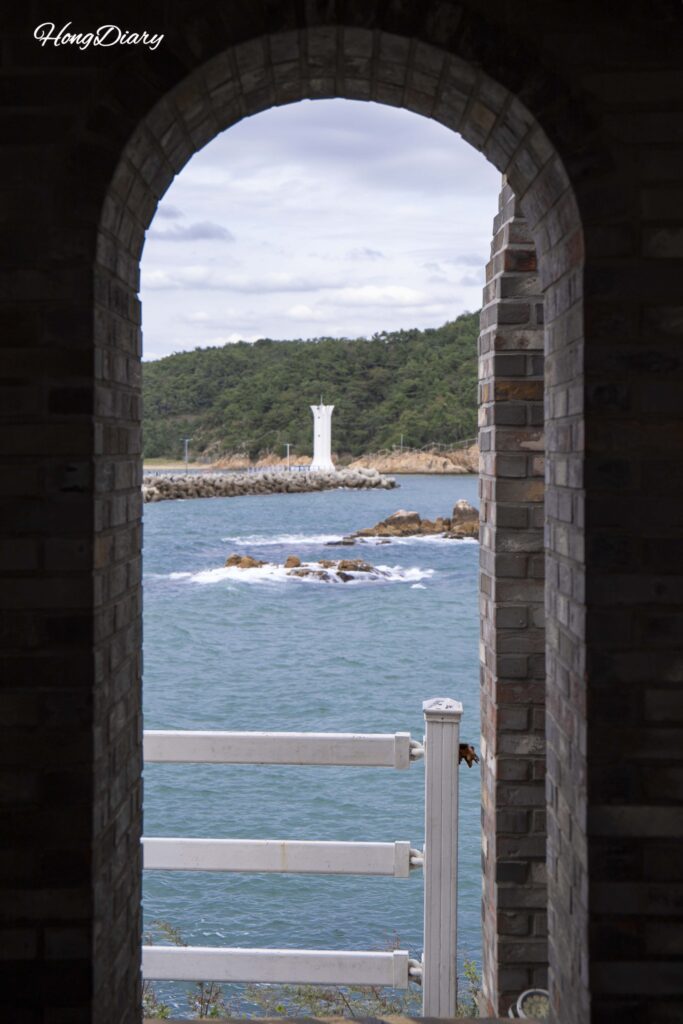View of the sea and lighthouse through the indoor photo zone at Jukseong Church, Busan