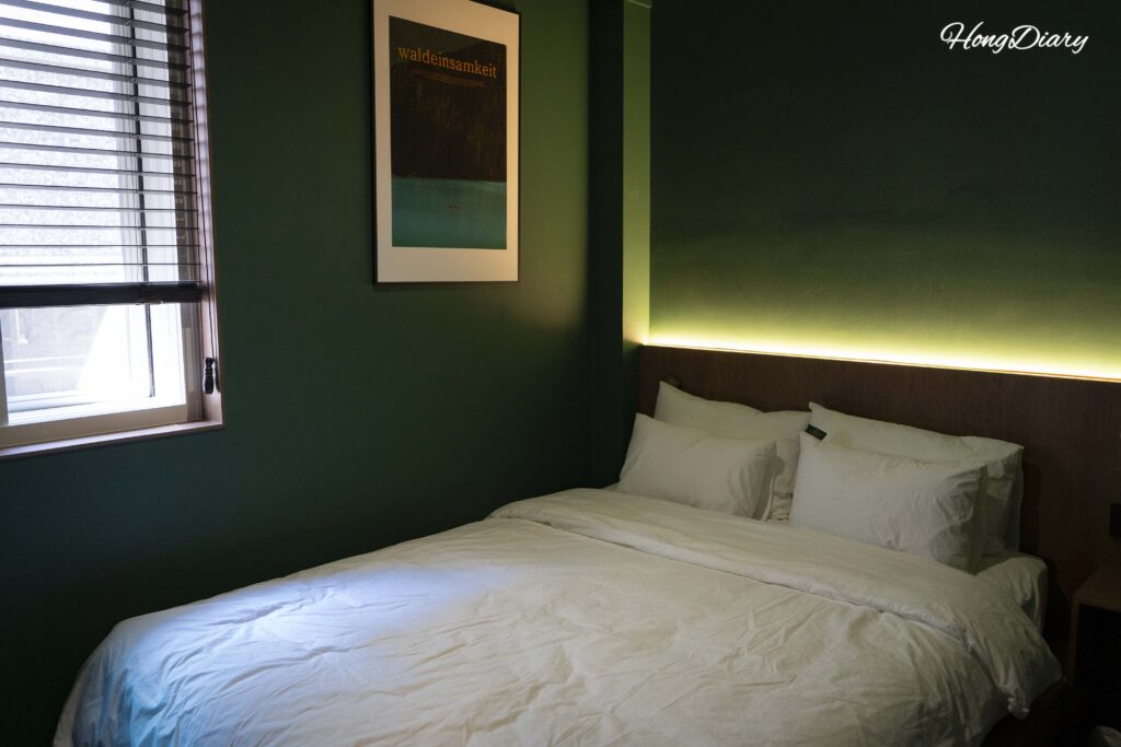 Close-up of the bed and bedside area with outlets at Kukjejang Hotel