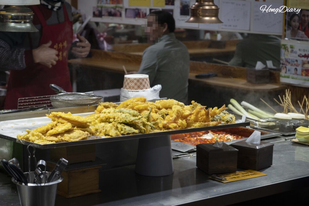 Frituras variadas preparadas en un puesto callejero dentro del Mercado Central de Jinju