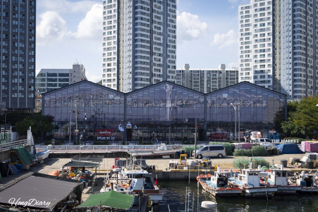 Millac The Market visto desde el rompeolas del puerto Minrak con botes pesqueros
