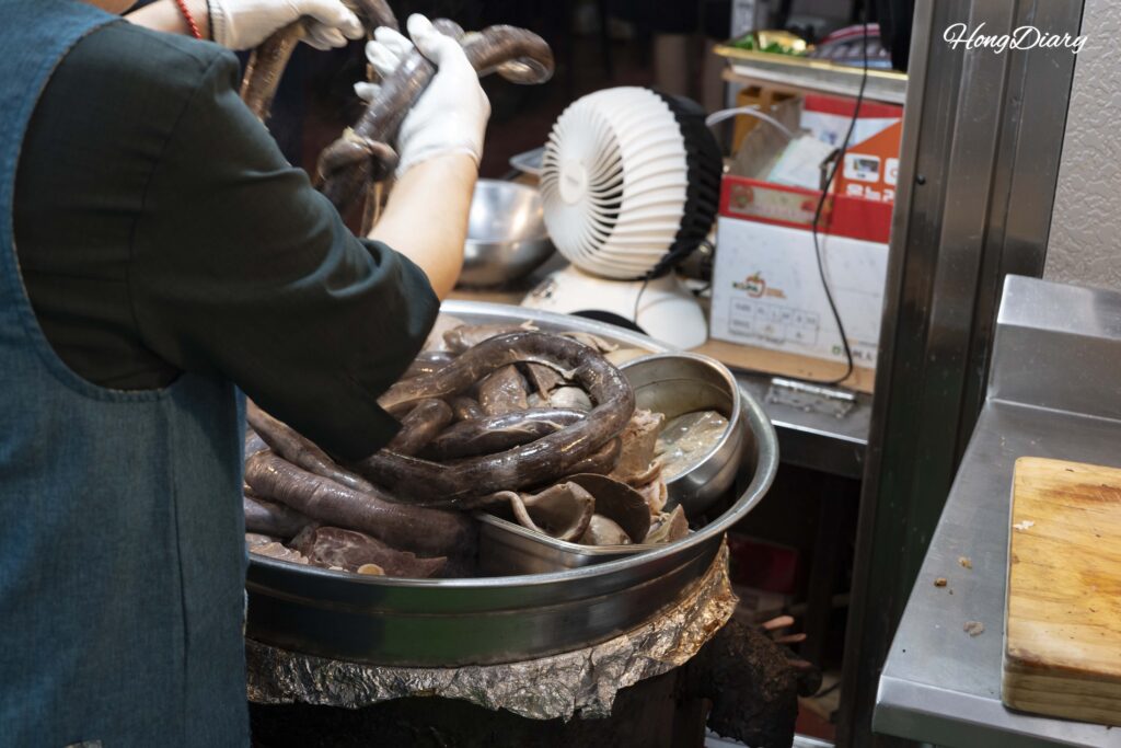 Staff steaming sundae (Korean blood sausage) at Oedong Chapssal Sundae stall inside Seongdong Market Gyeongju