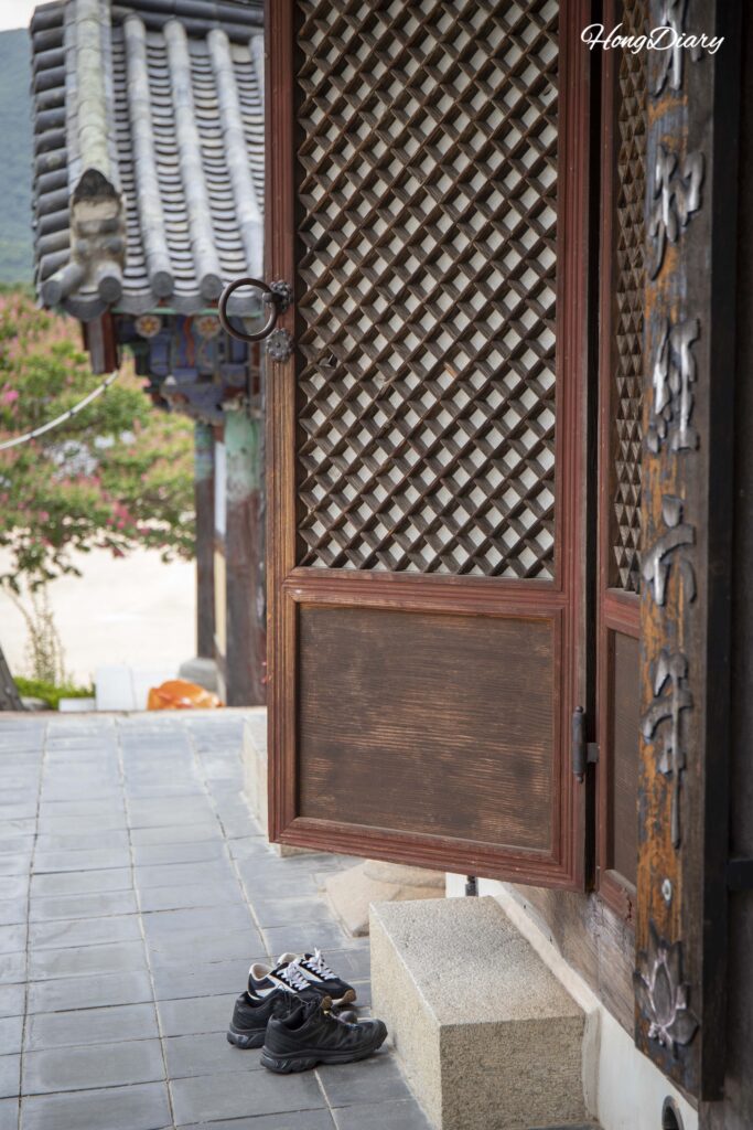 Doorway of Daegwangjeon Hall with visitors' shoes placed at the entrance of Pyochungsa Temple