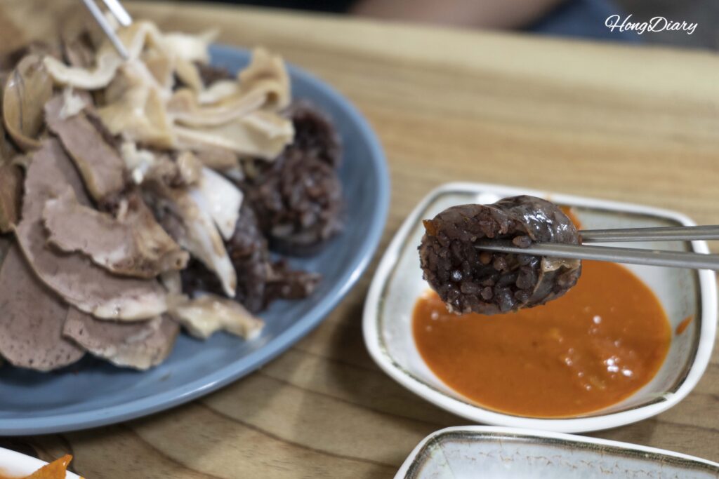 Close-up of sliced spicy sundae with extra organs from Oedong Chapssal Sundae at Seongdong Market Gyeongju, priced at 7000 won