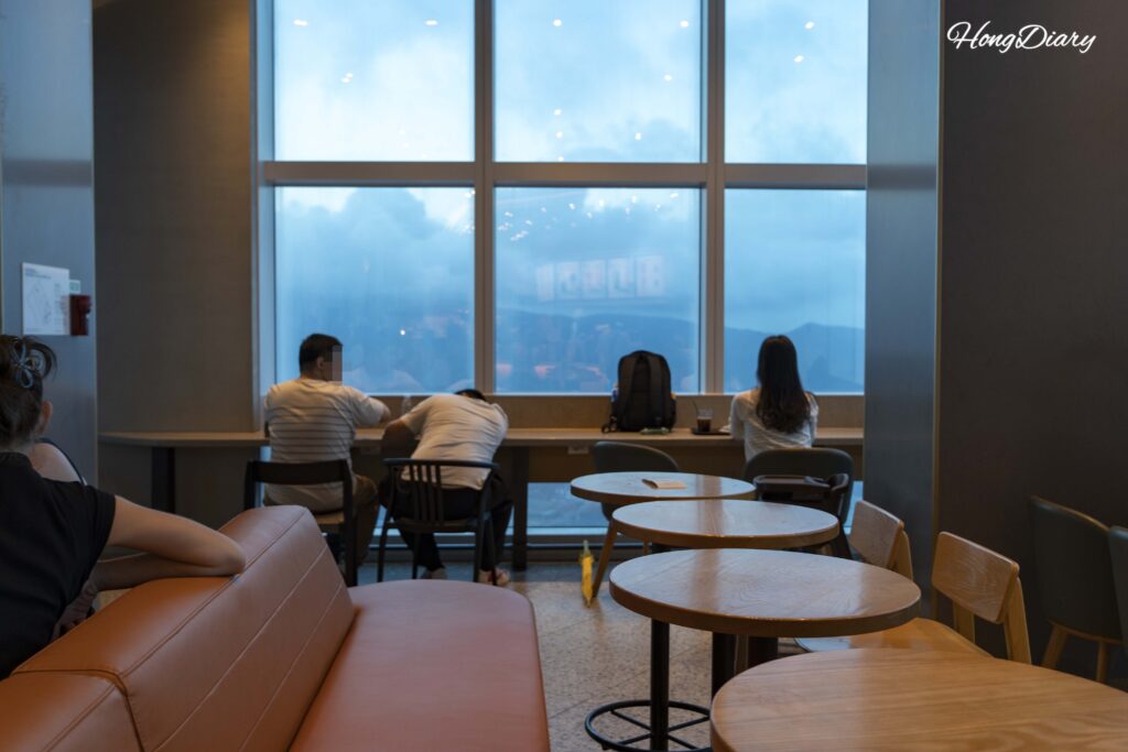 Mountain and coastal view seen through the window of the Starbucks at Busan X the Sky