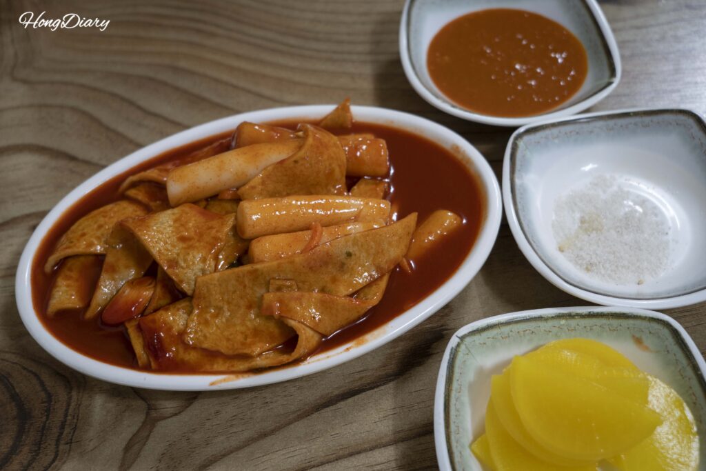 Plato de tteokbokki (pasteles de arroz en salsa dulce-picante) pedido como acompañamiento en el Mercado Seongdong en Gyeongju