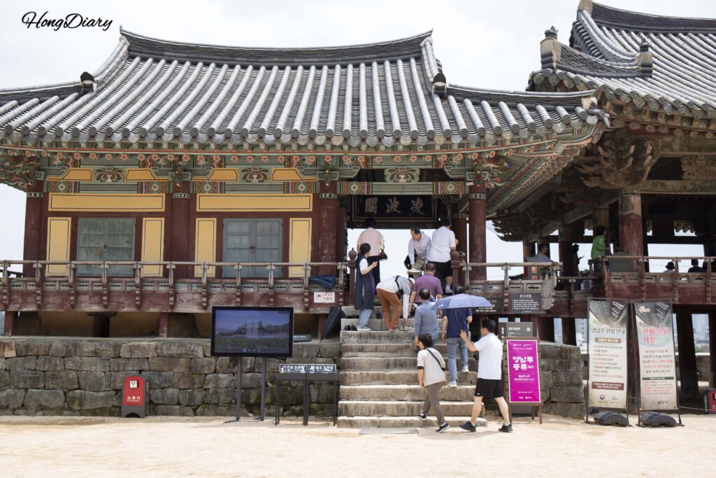 Visitantes quitándose los zapatos para subir al Pabellón Yeongnamnu en Miryang
