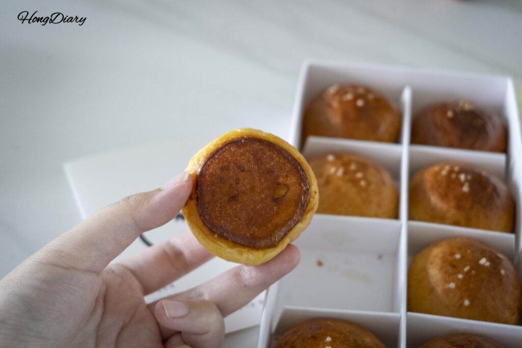 Bottom of a Wolji salt bread roll showing a golden crispy butter-baked crust