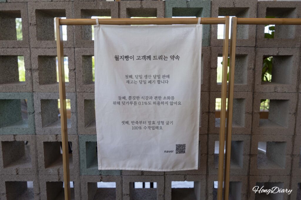 Wolji Bread customer promise sign listing same-day baking, no additives, and full handcraft policy