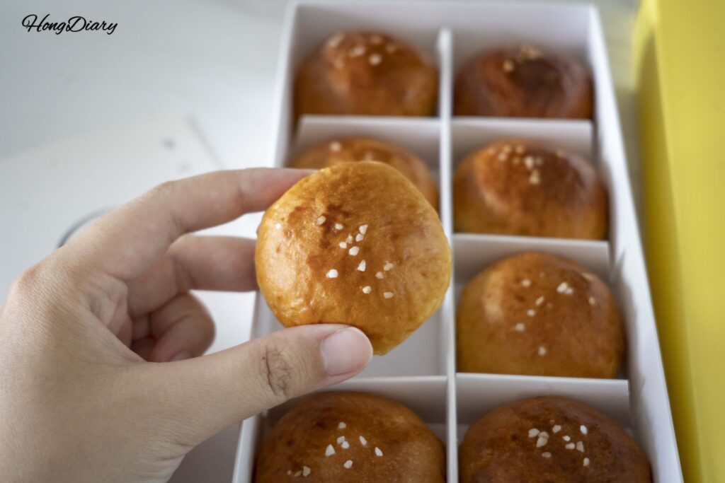 Close-up of a moon-shaped Wolji salt bread roll topped with coarse sea salt in Gyeongju