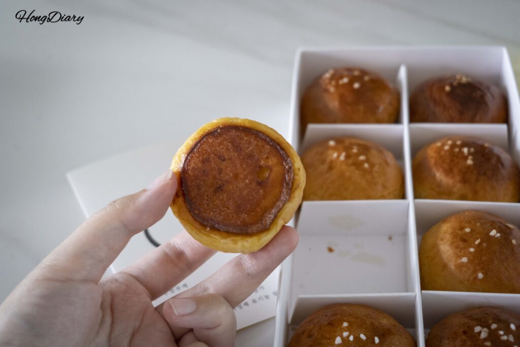 Pan de sal de Wolji Bread sostenido en la mano mostrando la sal gruesa encima