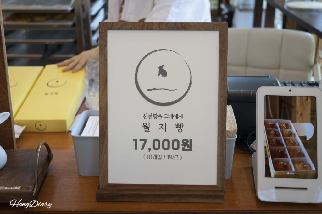 Wolji Bread price board showing a box of 10 salt bread rolls for 17,000 KRW(~$11 USD / €10 EUR)