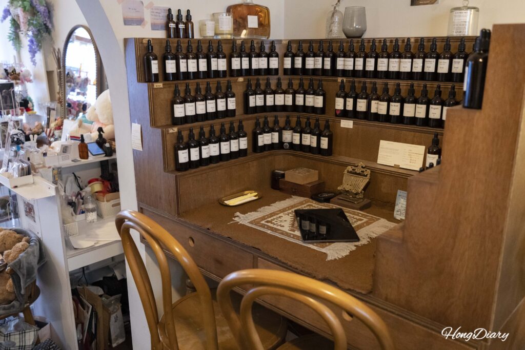 Sala de elaboración del taller de perfumes ADoR con mesas para dos personas y frascos de aceites aromáticos