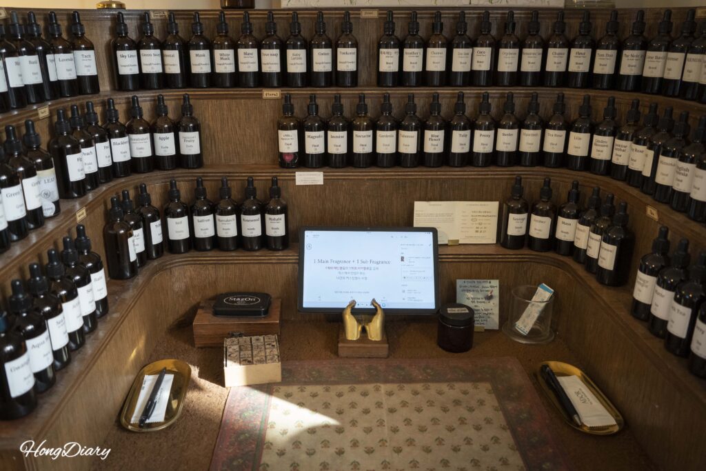 Wall display of over 100 fragrance oil bottles at ADoR Gwangalli perfume workshop