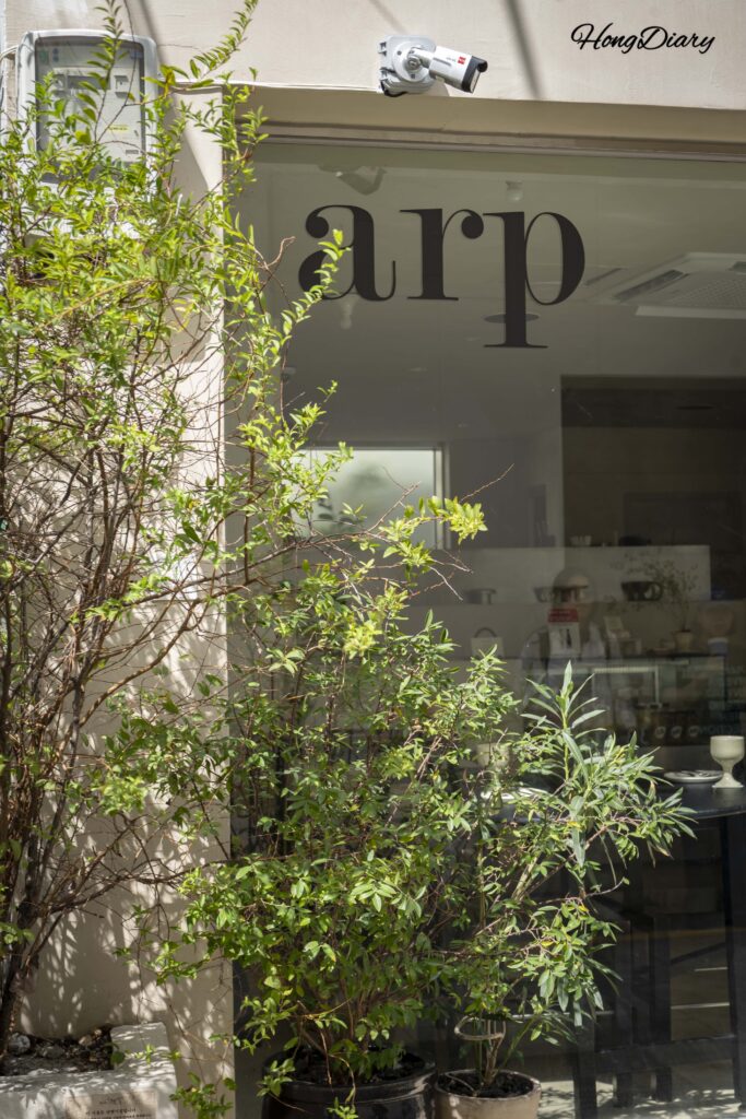 Fachada del restaurante vegano ARP en Yeongdo con el nombre impreso en el vidrio transparente