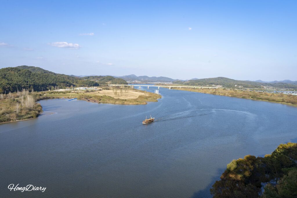 Barco turístico de estilo Baekje navegando el río Baengmagang bajo la Roca Nakhwaam en Buyeo