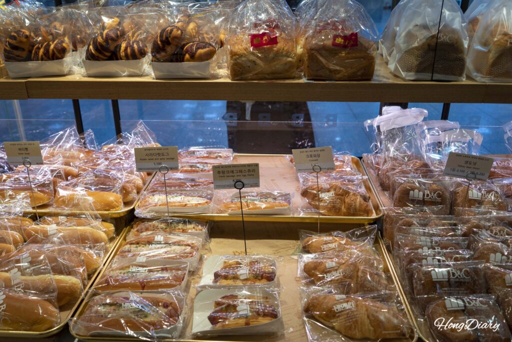 Assorted breads including croissants, butter bread, and sarada hot dogs at B&C Bakery Busan Station