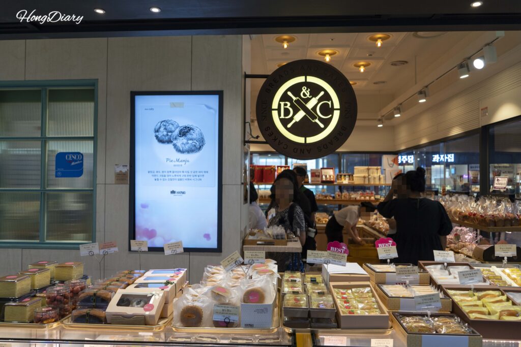 Customers selecting bread at B&C Bakery inside Busan Station, Dong-gu, Busan