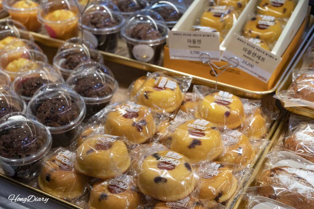 Madeleines de mermelada y panes variados en exhibición en la Panadería B&C, Estación de Busan