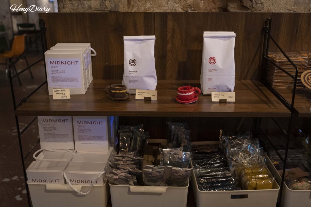 Branded merchandise and packaged coffee beans for sale at Brown Hands Baekje cafe in Busan