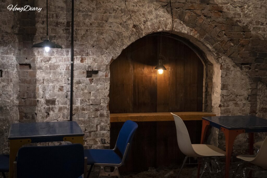 Interior de Brown Hands Baekje con paredes de ladrillo visto, marcos de madera antiguos e iluminación tenue