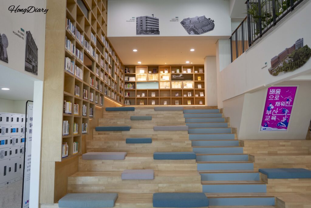 Sala de lectura del primer piso del Museo de Historia de la Educación de Busan, con estanterías y asientos cómodos