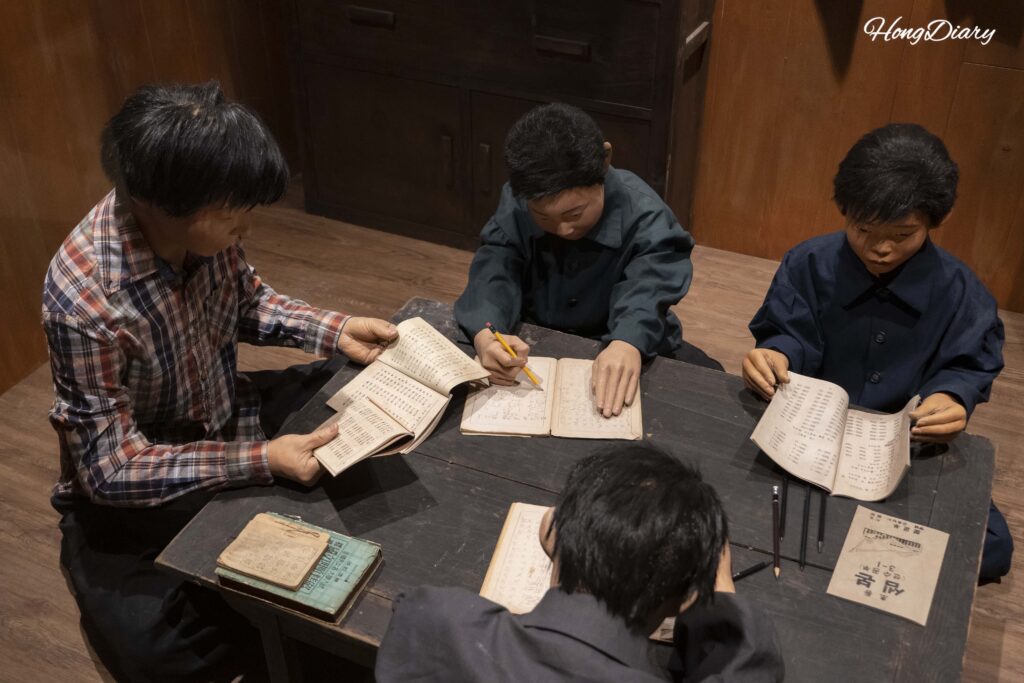 Maqueta a escala real de niños refugiados de la Guerra de Corea estudiando en su vivienda, exhibida en el Museo de Historia de la Educación de Busan