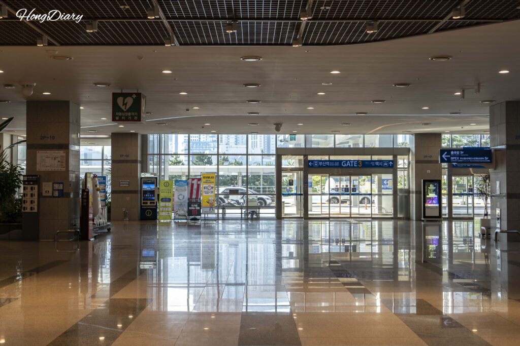 Interior del segundo piso de la terminal de ferris de Busan mostrando la puerta 3 y el amplio vestíbulo de llegadas