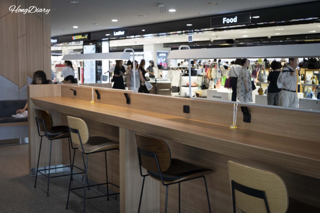 Sala de espera de embarque en la terminal de ferris de Busan con estaciones de carga y mesas