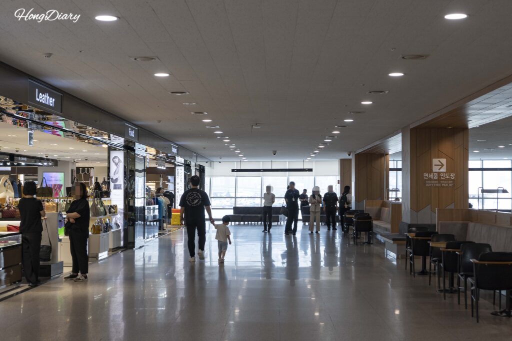 釜山港国際旅客ターミナルの免税店で商品を見る旅行者たち