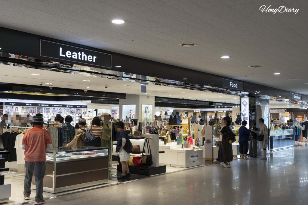 Duty-free shopping area inside Busan Port International Passenger Terminal after the immigration checkpoint, with passengers browsing