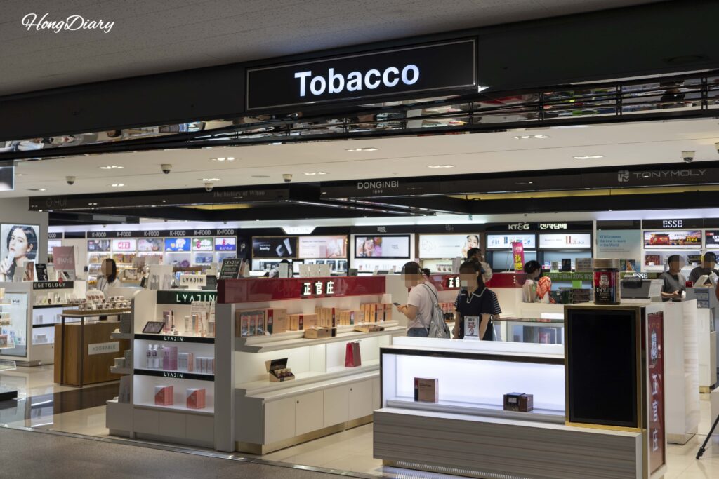 釜山港国際旅客ターミナルの出国審査後に広がる免税売場と買い物客