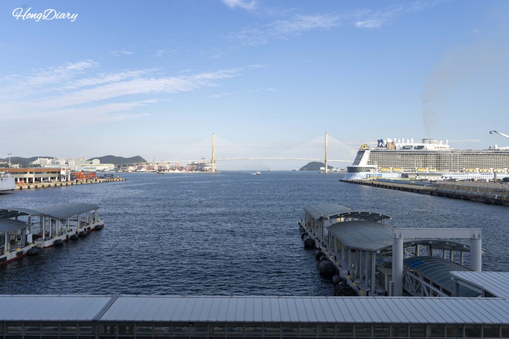 View of Busan Harbor Bridge and a large cruise ship docked at Busan Port, seen from the pedestrian skywalk to the ferry terminal