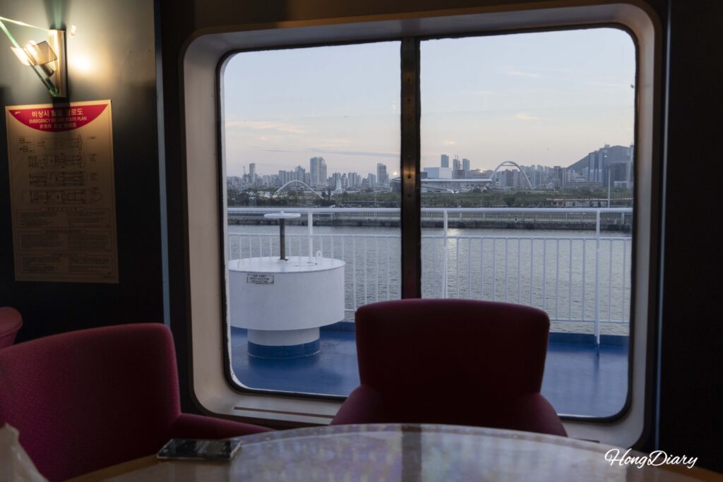 Atardecer sobre el Puerto de Busan visto desde la ventana del Multi Hall del ferry Seonghee