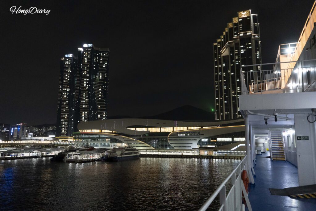 Busan port skyline and terminal buildings at night viewed from the Seonghee ferry deck