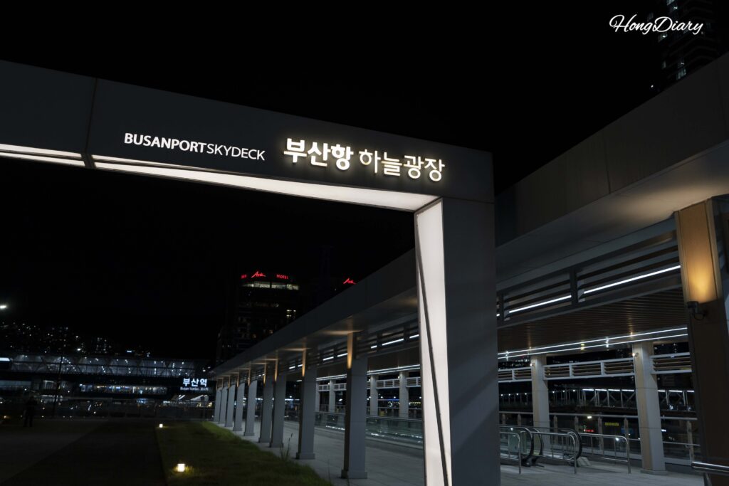 Sky Plaza (Haneul Gwangjang) al atardecer, con vista hacia North Port Waterfront Park desde el puente peatonal elevado