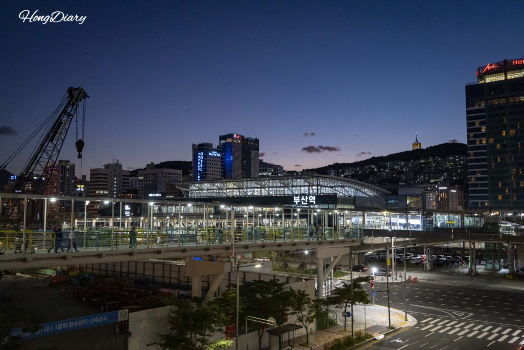Vista nocturna de la Estación de KTX Busan iluminada, punto de partida para caminar hacia North Port Waterfront Park