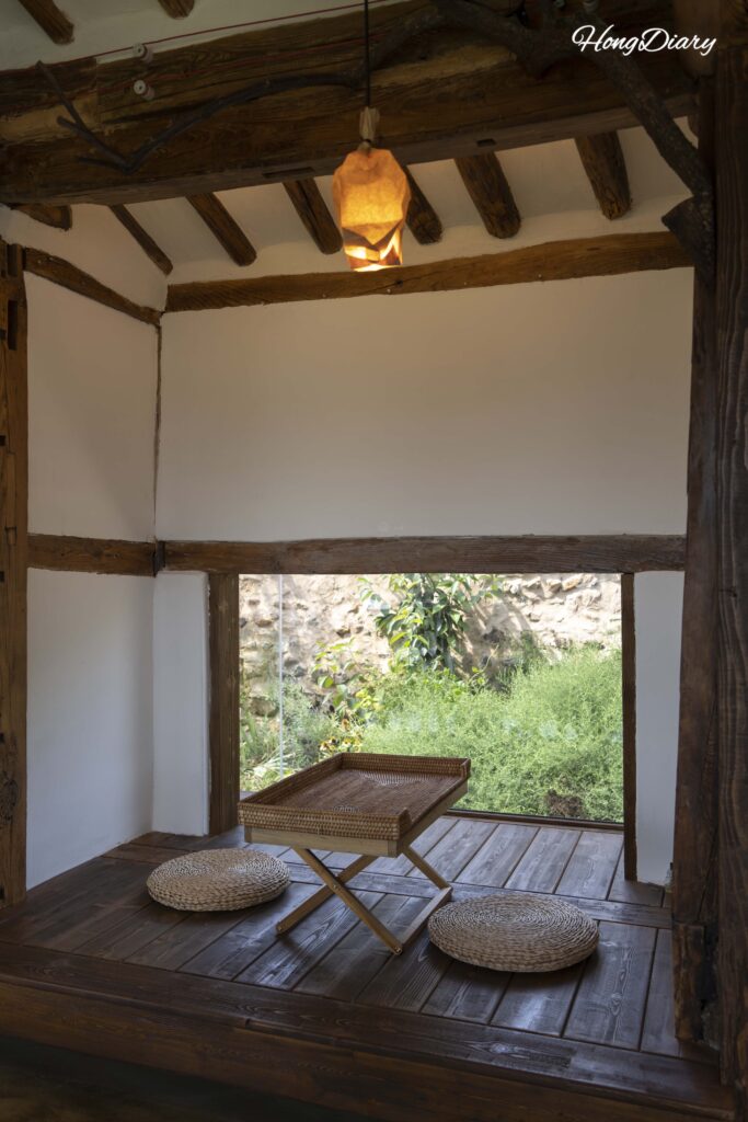 Interior of Byeotnwi anchae with mixed seating and natural light through large windows in Miryang