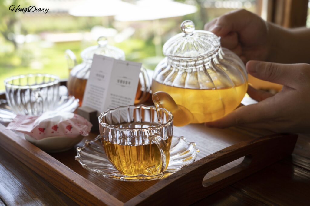 Pouring herbal tea from a clay teapot into a cup at Byeotnwi hanok cafe in Miryang