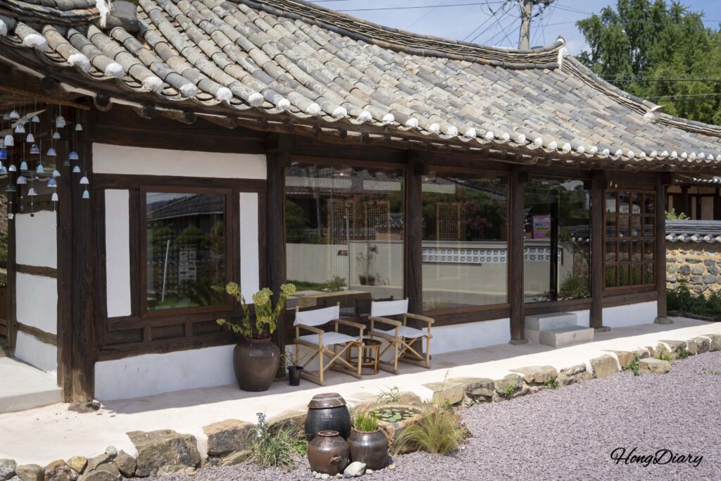 Exterior del sarangchae de Byeotnwi con sillas al aire libre y campanillas de cerámica punggyeong