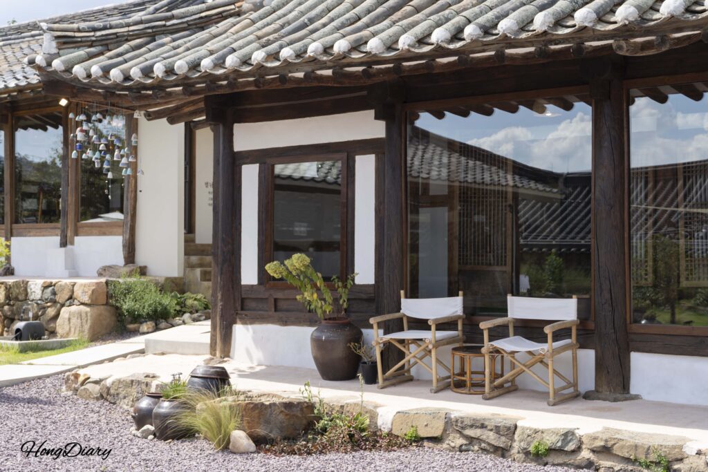 Exterior of Byeotnwi sarangchae guest quarters with outdoor seating and ceramic punggyeong wind chimes