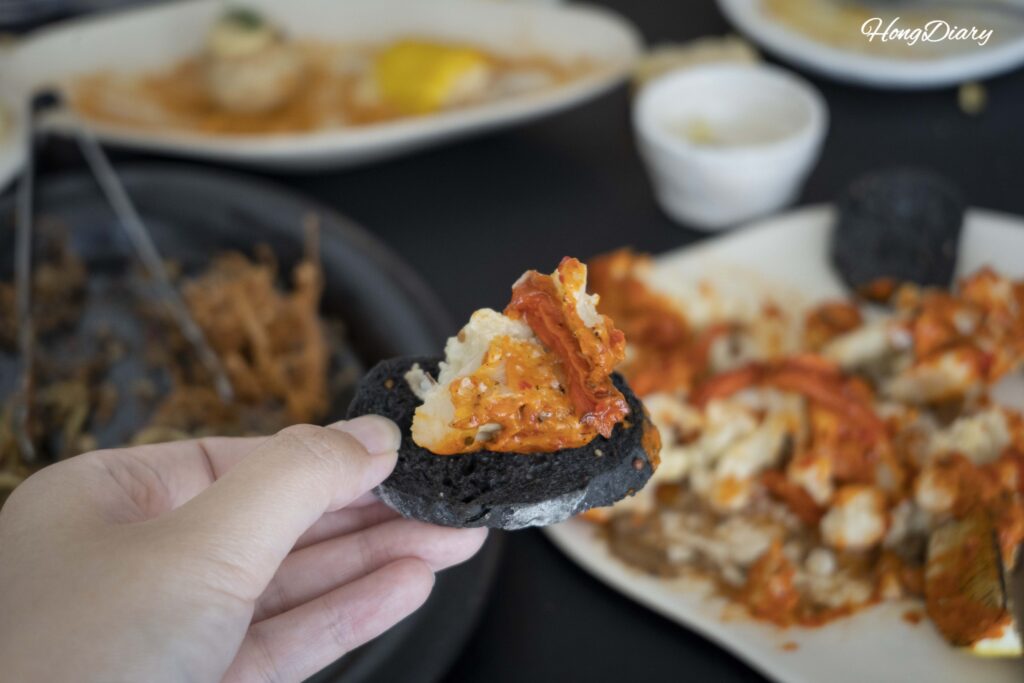 Closeup of roasted cauliflower placed on dark-colored bread with toppings at ARP vegan restaurant in Busan