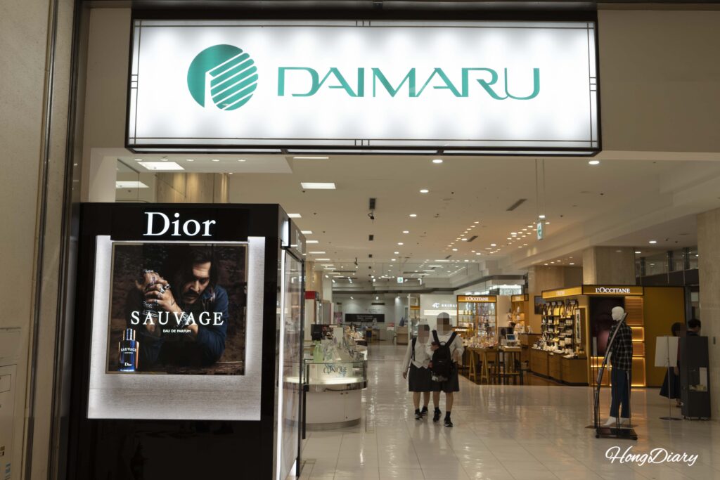 Entrada de los grandes almacenes Daimaru Shimonoseki con el logotipo y compradores