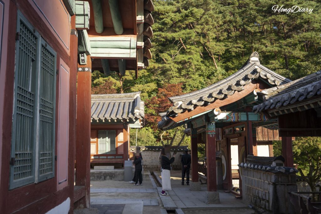 Edificios interiores de Dosan Seowon enmarcados por follaje otoñal, Andong